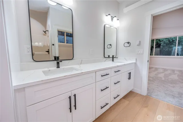 a bathroom with double sink and a mirror