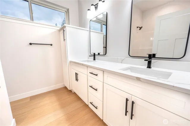 a bathroom with a double vanity sink and mirror