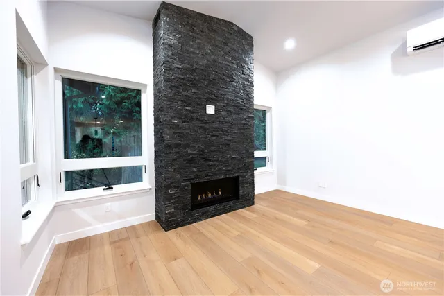 a view of an empty room with a fireplace and a window