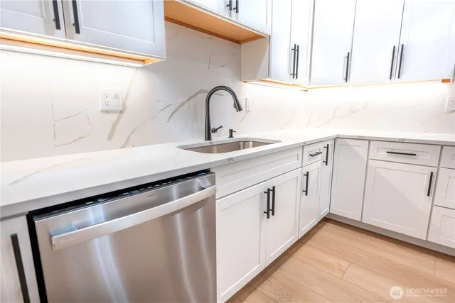 a kitchen with white cabinets and sink