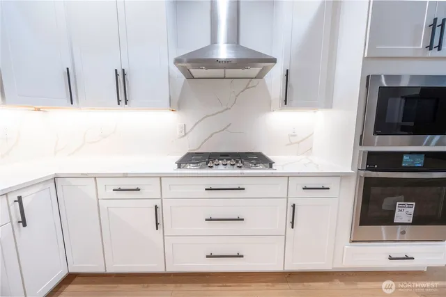 a kitchen with granite countertop white cabinets and white appliances