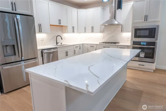 a kitchen with stainless steel appliances a refrigerator a stove and a sink