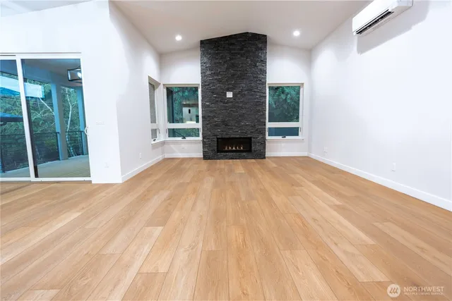 a view of a livingroom with a fireplace wooden floor and window