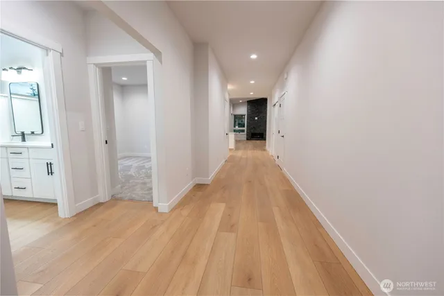 a view of a hallway with wooden floor and staircase