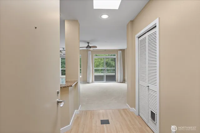 a view of a hallway with wooden floor and a bathroom