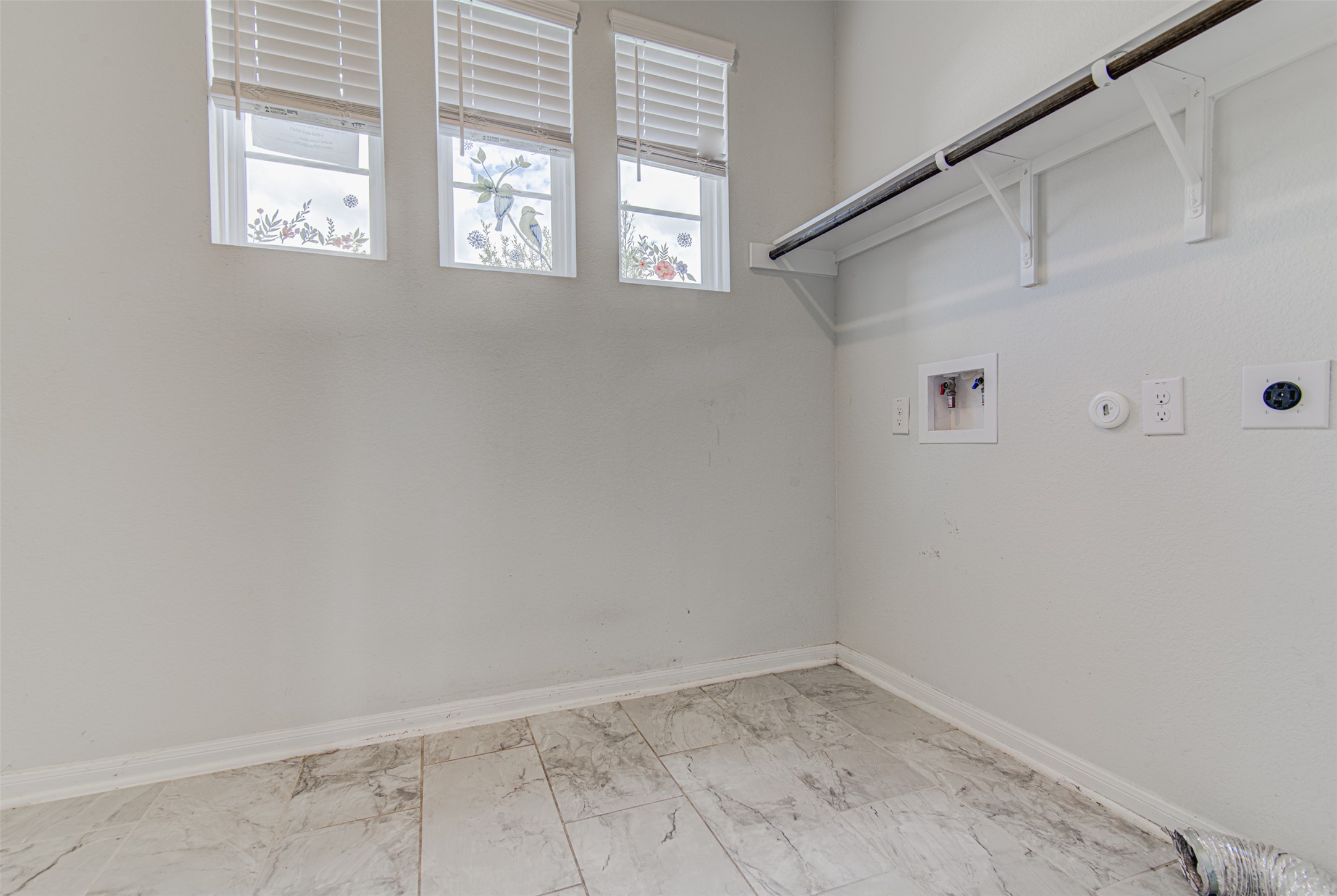 774 Cherrystone Loop Buda, TX 78610 - Photo 11 of 38 Ample space for laundry appliances with convenient hookups and a practical clothes hanging rod.
