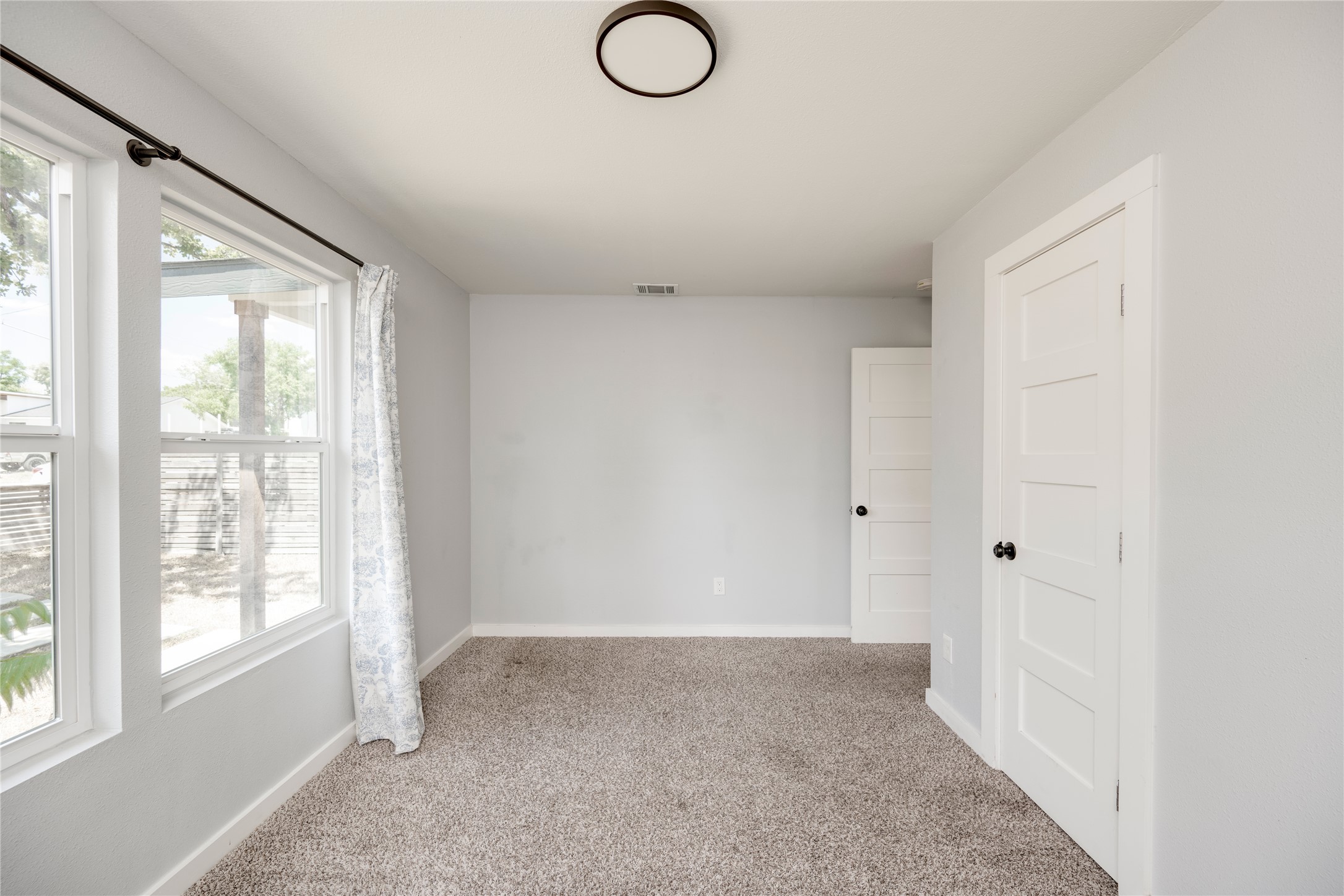 1400 Marcus Place, Unit B Austin, TX 78721 - Photo 15 of 39 Natural light filters into this well-lit room, featuring comfortable carpet and contemporary paneled doors.