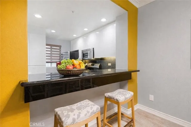 a dining room with furniture a rug a potted plant and a chandelier