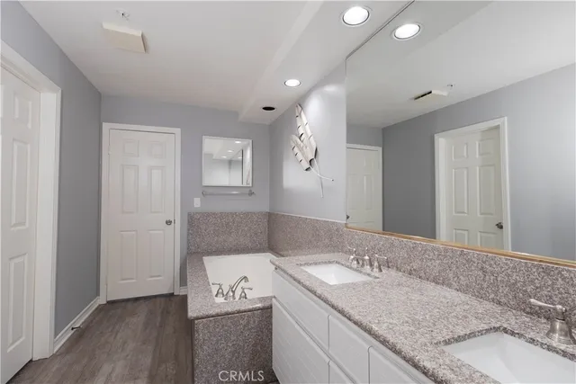 a bathroom with a tub sink and mirror