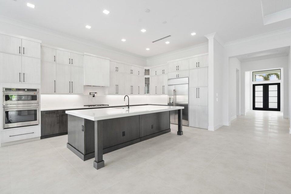 170 Southeast Rio Angelica Port St. Lucie, FL 34984 - Photo 10 of 55 a kitchen with kitchen island a sink stainless steel appliances and white cabinets