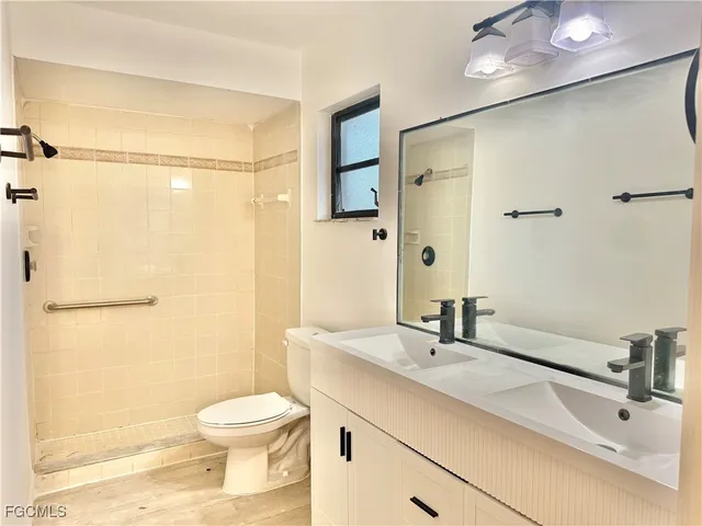 a bathroom with a sink toilet a mirror and shower