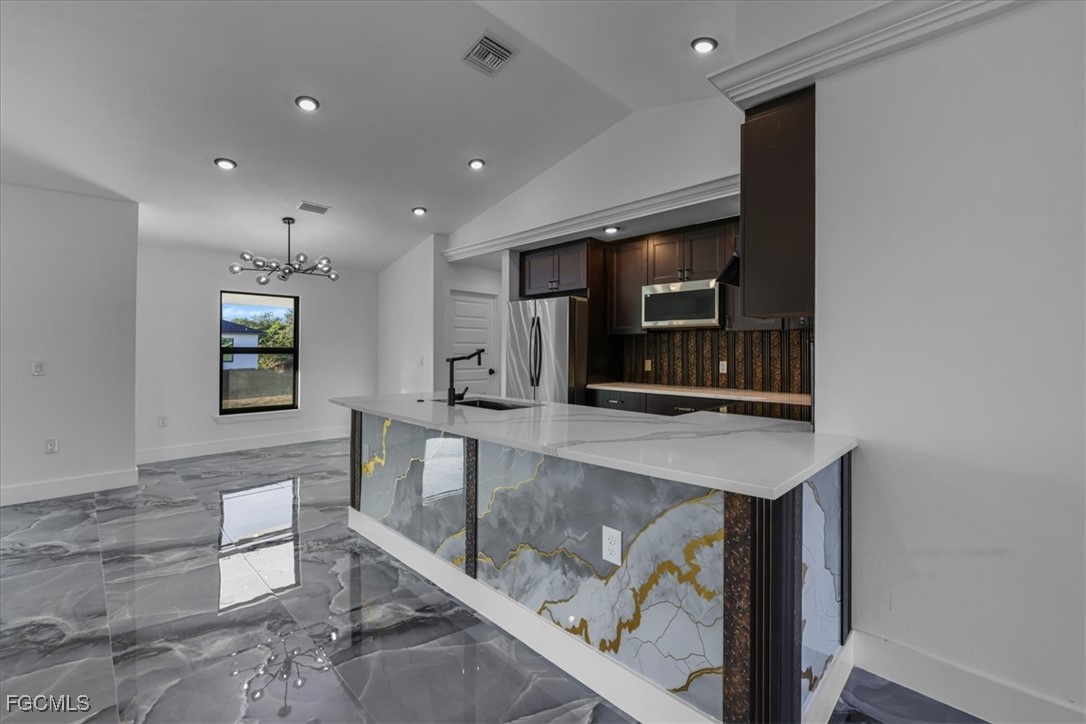2901 2nd Street Southwest Lehigh Acres, FL 33976 - Photo 18 of 40 a kitchen with stainless steel appliances wooden cabinets and a counter top space