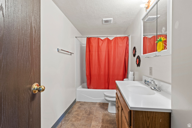 2402 710 North Provo, UT 84601 - Photo 10 of 15 Bathroom featuring a wood-finish vanity with an integrated sink and chrome faucet, a medicine cabinet, and a white bathtub with a shower kit