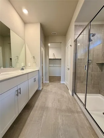a spacious bathroom with a glass shower door and a sink
