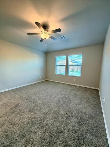 an empty room with windows and ceiling fan view