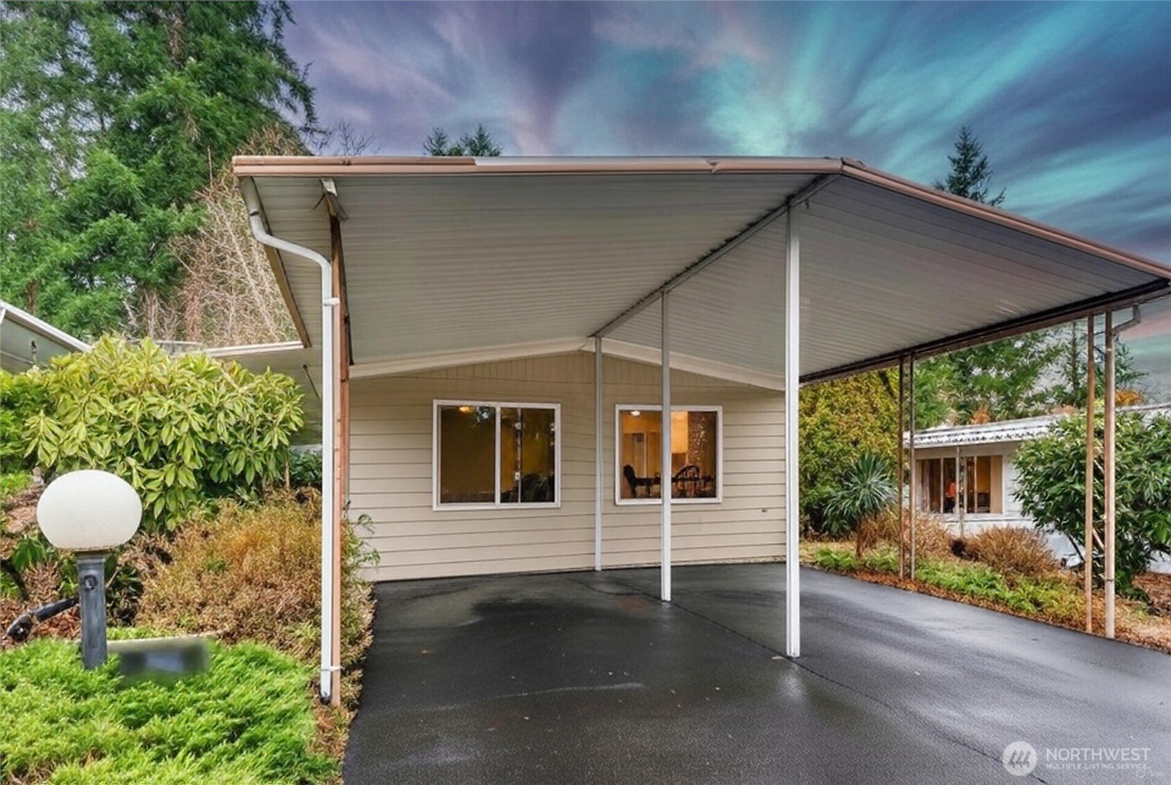 a backyard of a house with table and chairs under an umbrella
