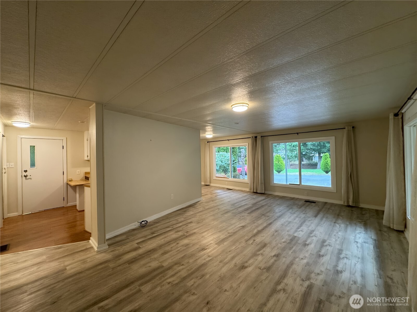 201 Union Avenue Southeast, Unit 154 Renton, WA 98059 - Photo 2 of 10 an empty room with wooden floor and windows