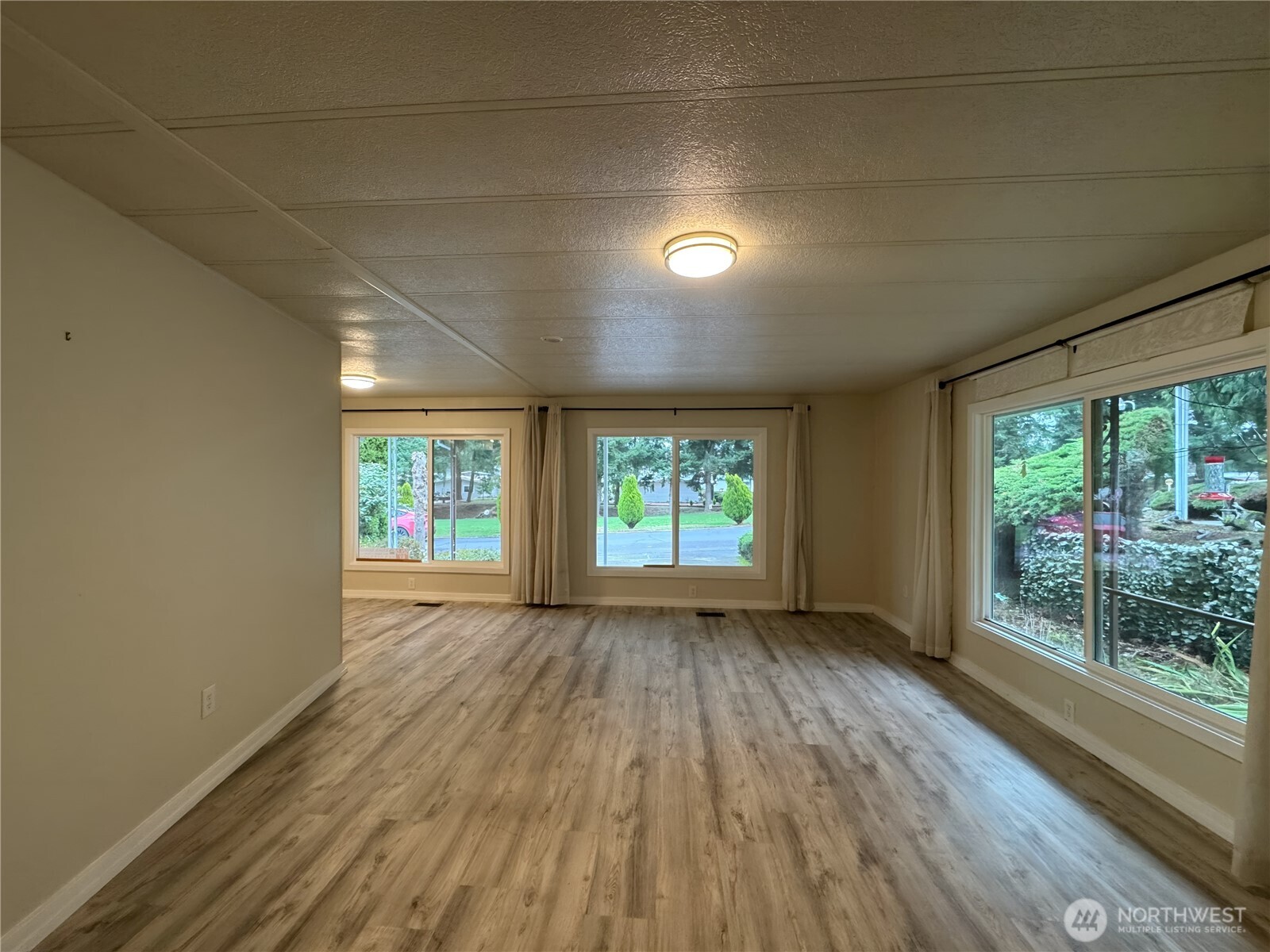 201 Union Avenue Southeast, Unit 154 Renton, WA 98059 - Photo 3 of 10 an empty room with wooden floor and windows