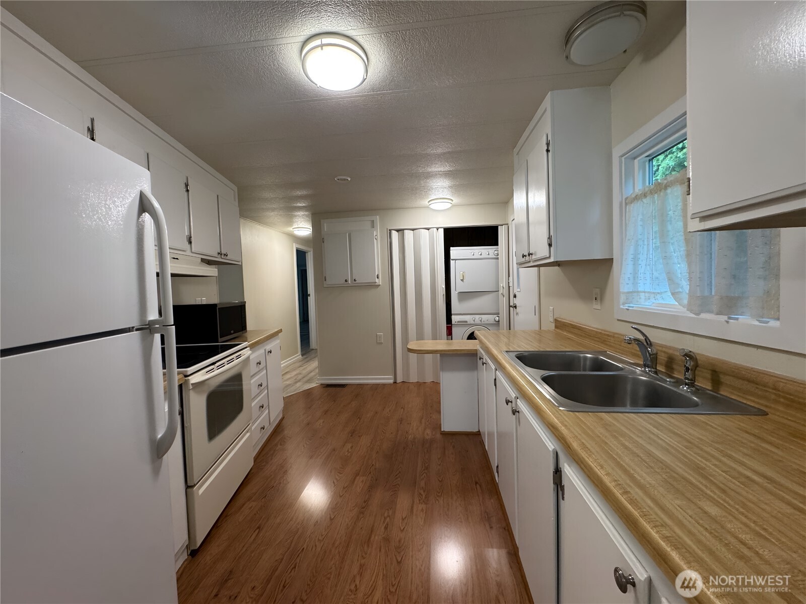 201 Union Avenue Southeast, Unit 154 Renton, WA 98059 - Photo 5 of 10 a kitchen with a sink a refrigerator and a stove top oven
