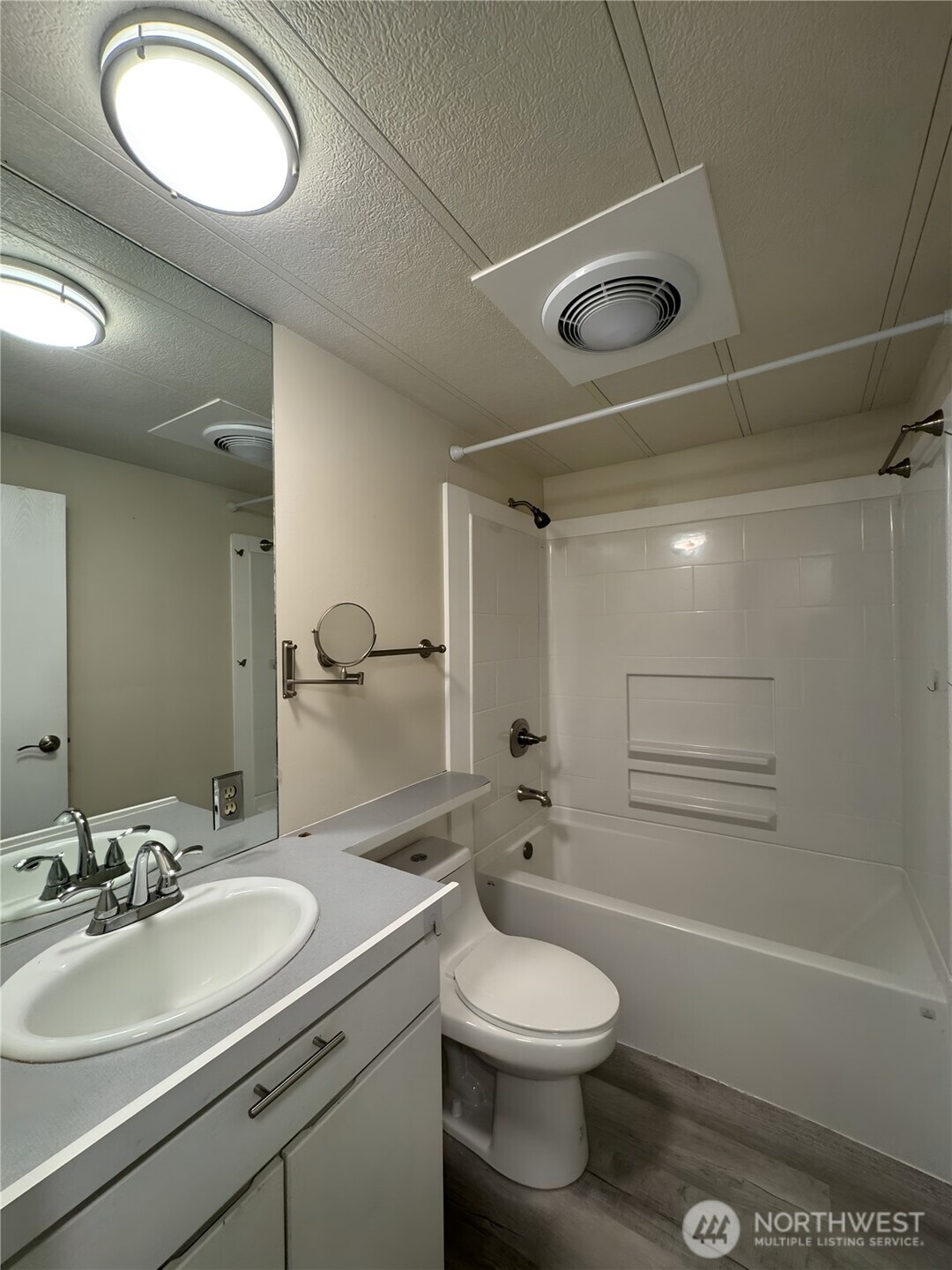 201 Union Avenue Southeast, Unit 154 Renton, WA 98059 - Photo 7 of 10 a bathroom with a toilet a sink a mirror and a shower