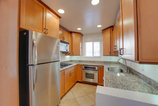 a kitchen with stainless steel appliances granite countertop a refrigerator a sink and a refrigerator