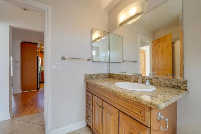 a bathroom with a granite countertop sink and a mirror
