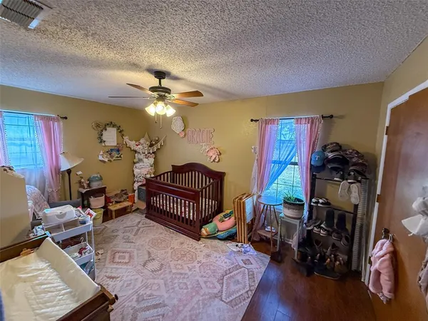 a room with furniture a air conditioner vent and a window