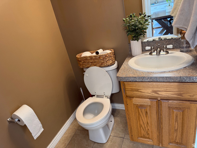 183 East 820 South Centerville, UT 84014 - Photo 7 of 14 Bathroom featuring a single vanity with wood-finish cabinetry, a speckled countertop, and a white porcelain sink