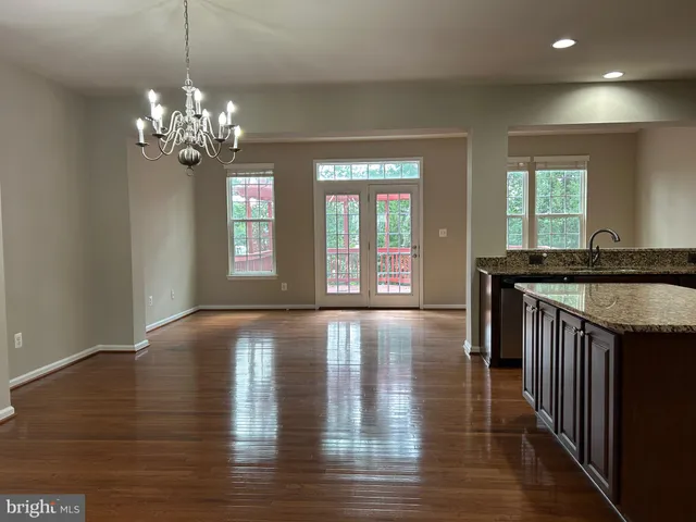 a view of a kitchen with granite countertop wooden floor and a chandelier