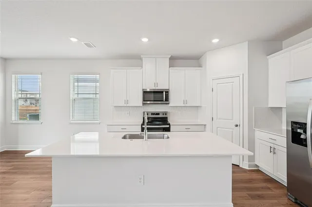 a kitchen with stainless steel appliances a stove a sink a microwave and cabinets