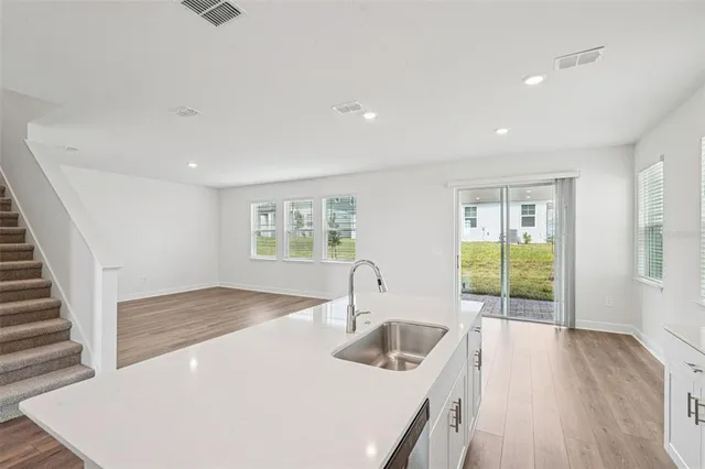a kitchen with sink and view of living room