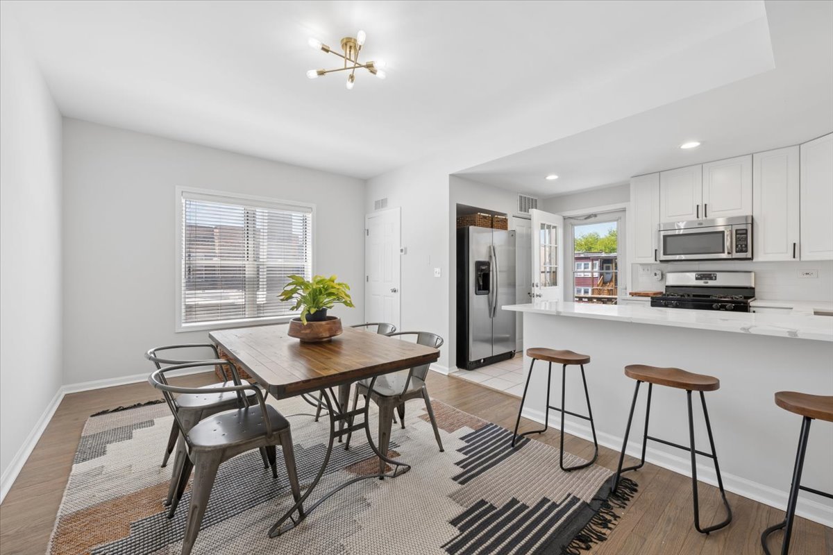 6348 North Magnolia Avenue, Unit 3 Chicago, IL 60660 - Photo 11 of 19 a view of a dining room with furniture and a chandelier