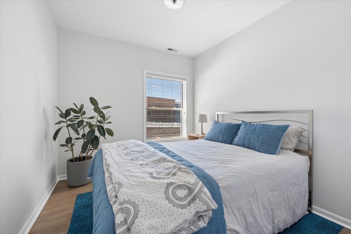 6348 North Magnolia Avenue, Unit 3 Chicago, IL 60660 - Photo 10 of 19 a bedroom with a bed and a potted plant