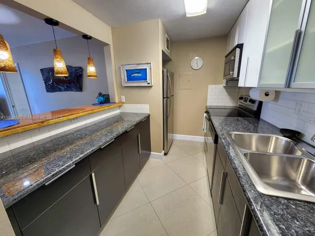 a kitchen with stainless steel appliances granite countertop a sink and a stove