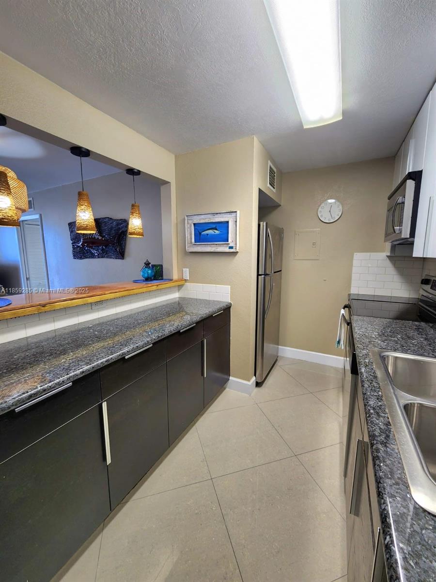 88500 Overseas Highway, Unit 301 Islamorada, FL 33036 - Photo 16 of 24 a kitchen with stainless steel appliances granite countertop a sink and a stove
