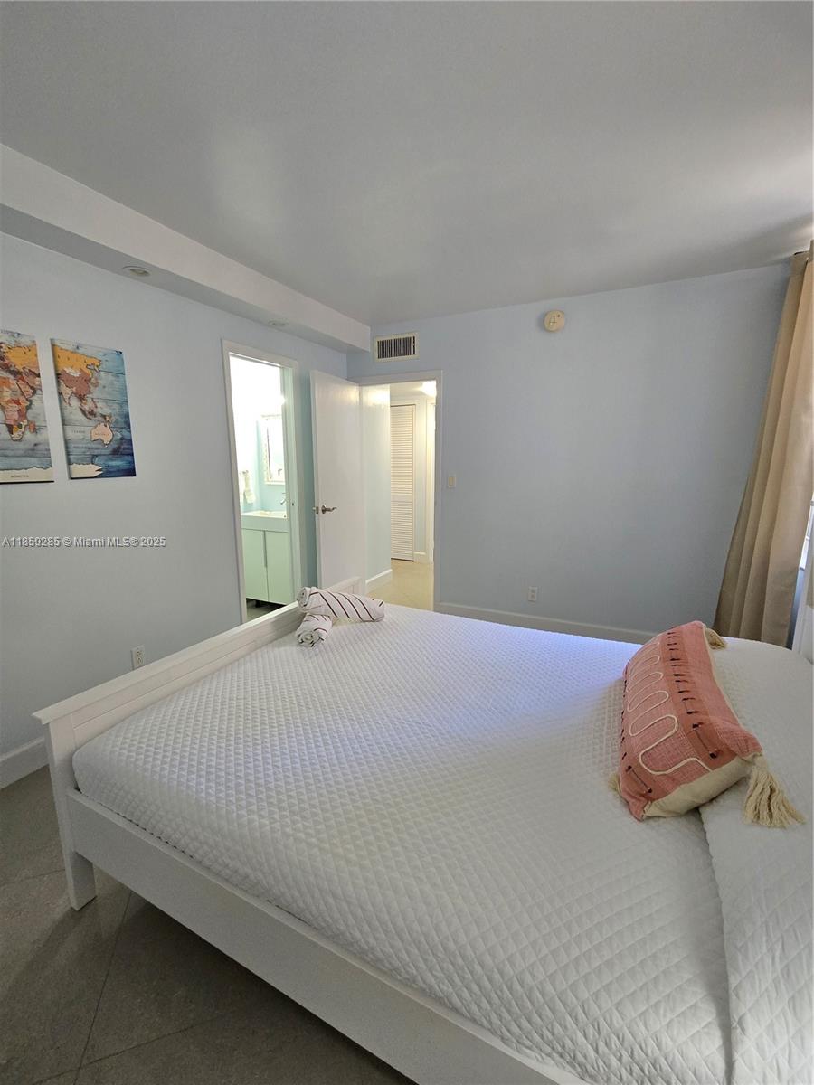 88500 Overseas Highway, Unit 301 Islamorada, FL 33036 - Photo 22 of 24 a bedroom with a bed and a chandelier