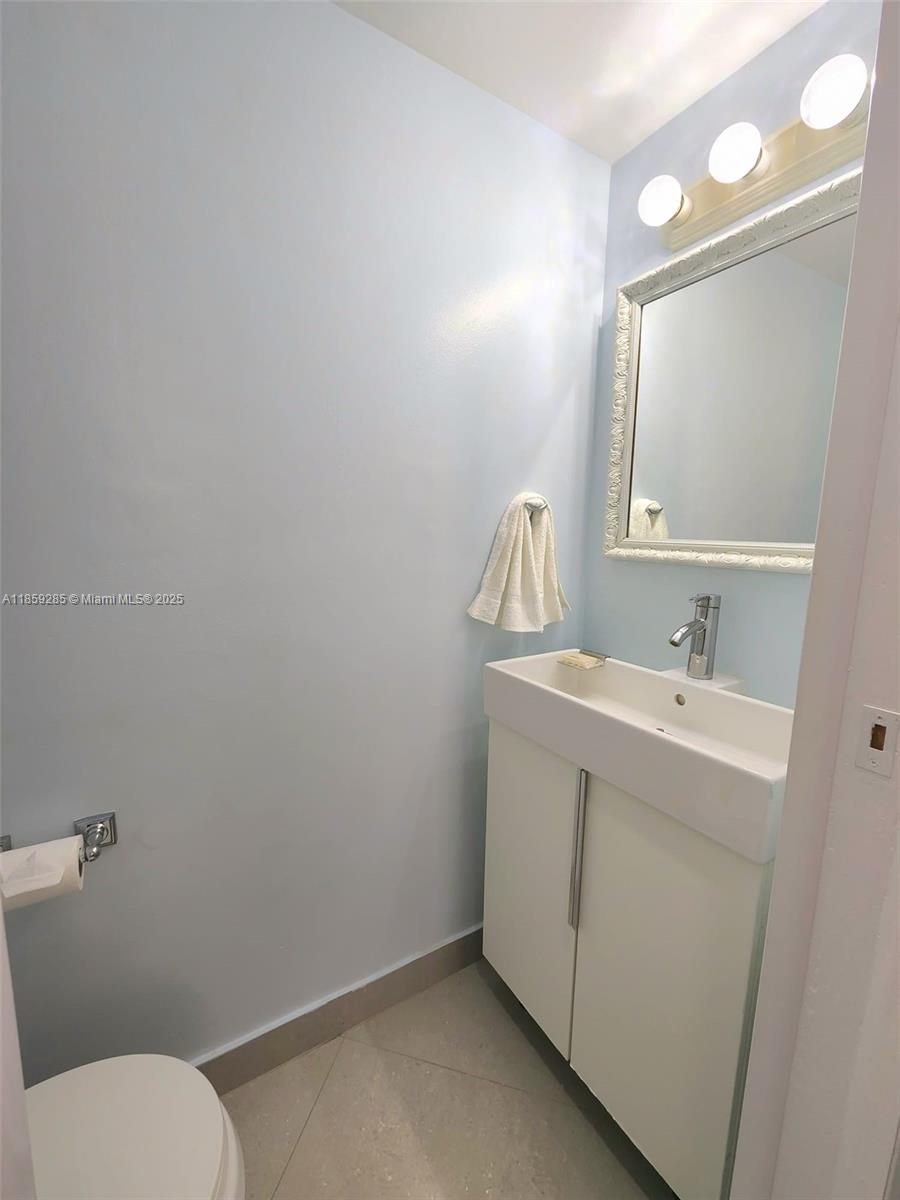 88500 Overseas Highway, Unit 301 Islamorada, FL 33036 - Photo 24 of 24 a bathroom with a toilet sink and mirror