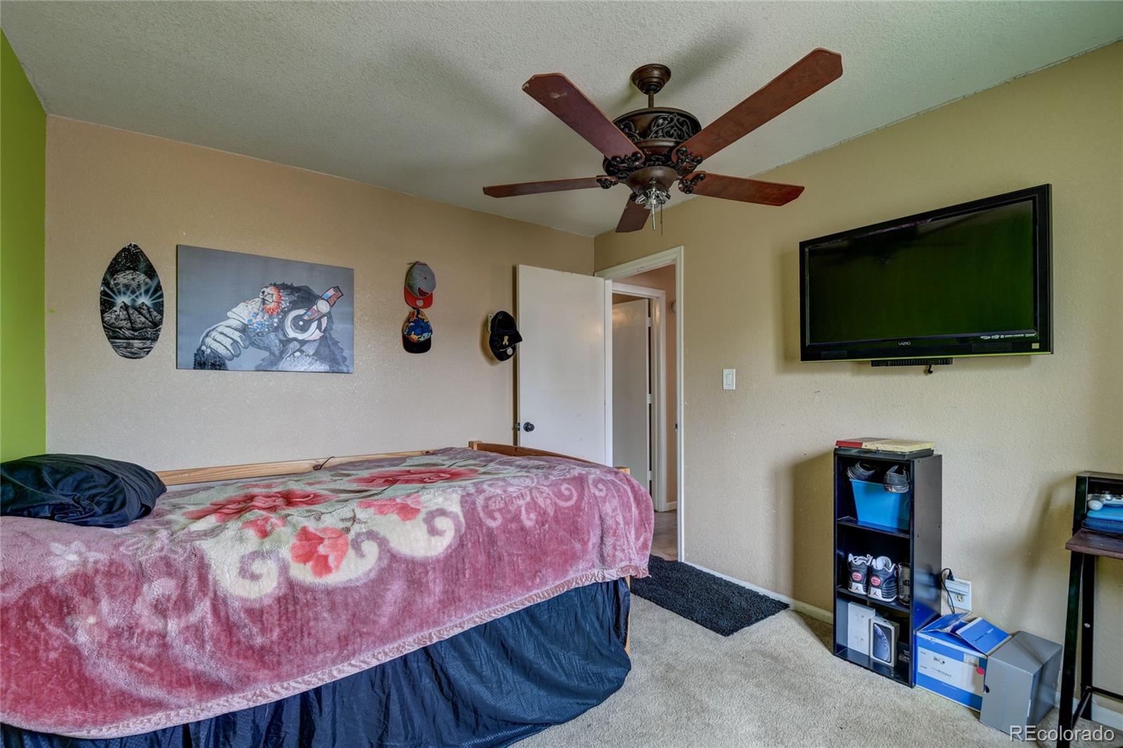 820 South Denver Avenue Fort Lupton, CO 80621 - Photo 14 of 40 a bedroom with a bed and a flat screen tv
