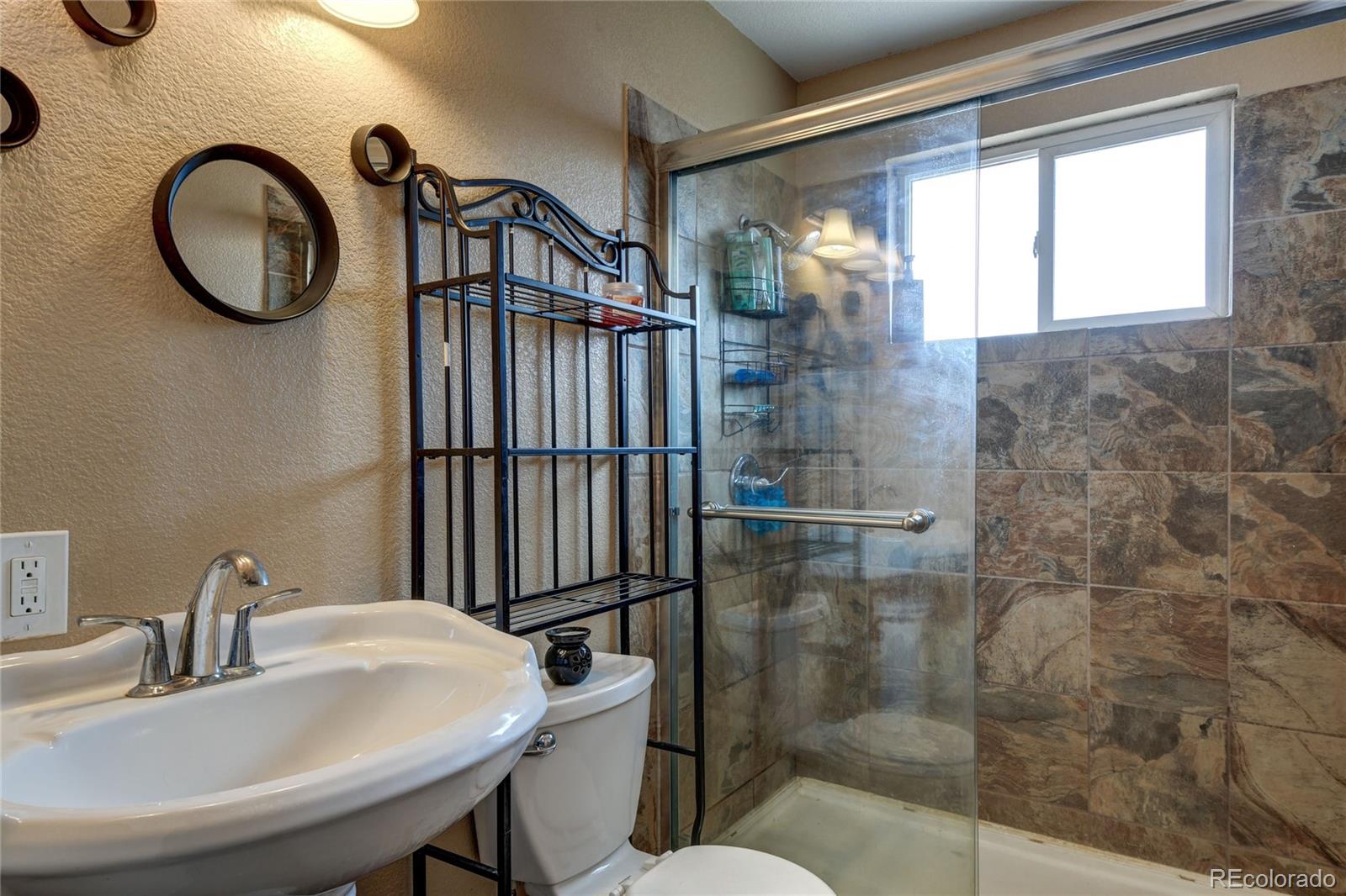 820 South Denver Avenue Fort Lupton, CO 80621 - Photo 17 of 40 a bathroom with a sink mirror toilet and shower
