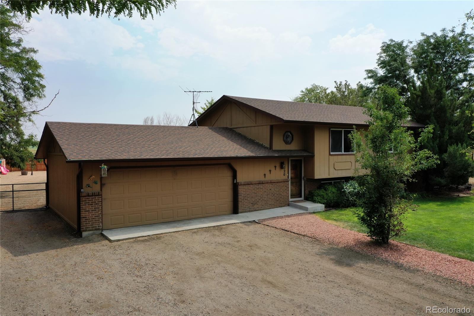 820 South Denver Avenue Fort Lupton, CO 80621 - Photo 29 of 40 a front view of a house with a yard and garage