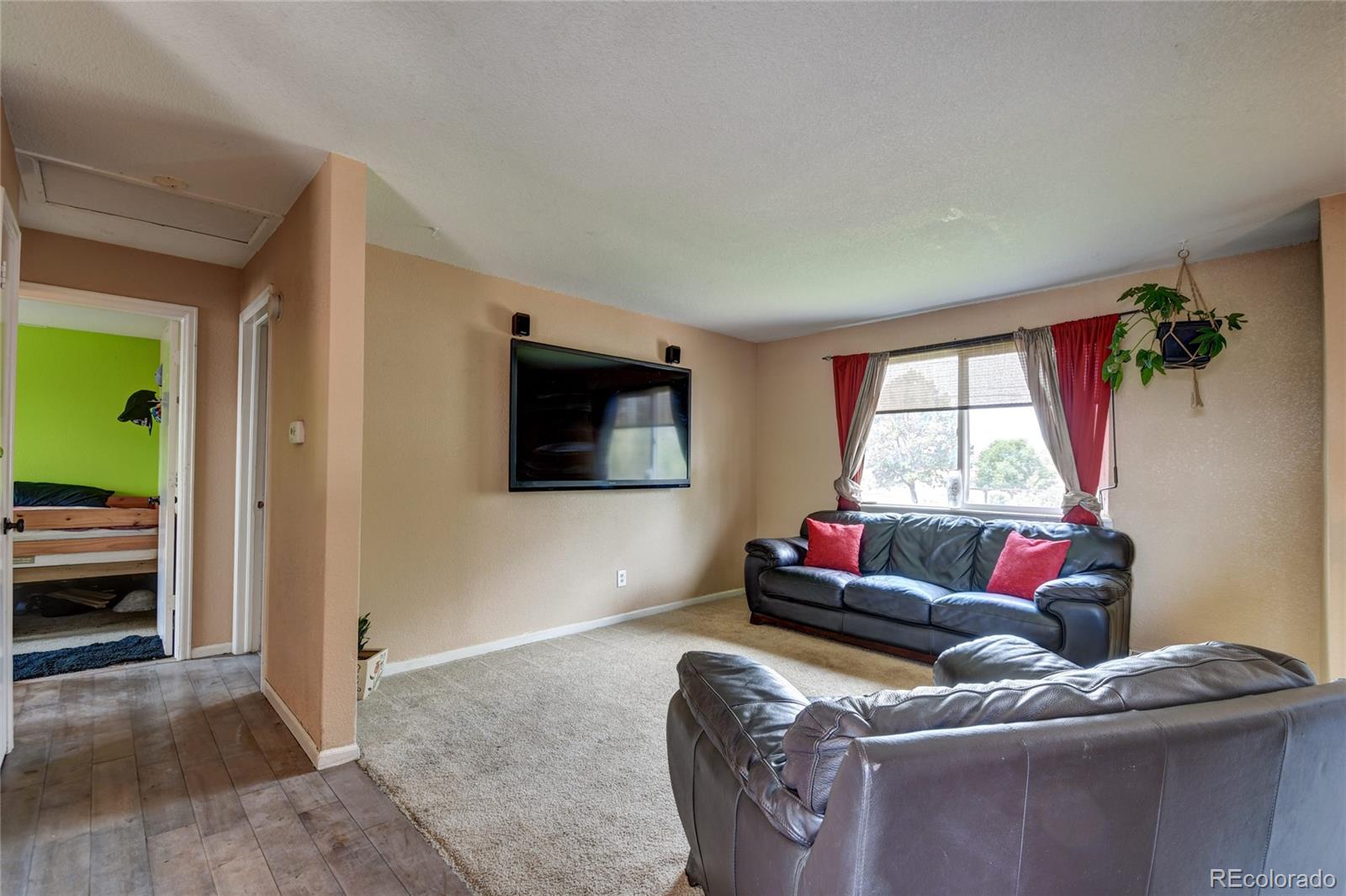 820 South Denver Avenue Fort Lupton, CO 80621 - Photo 4 of 40 a living room with furniture and a flat screen tv