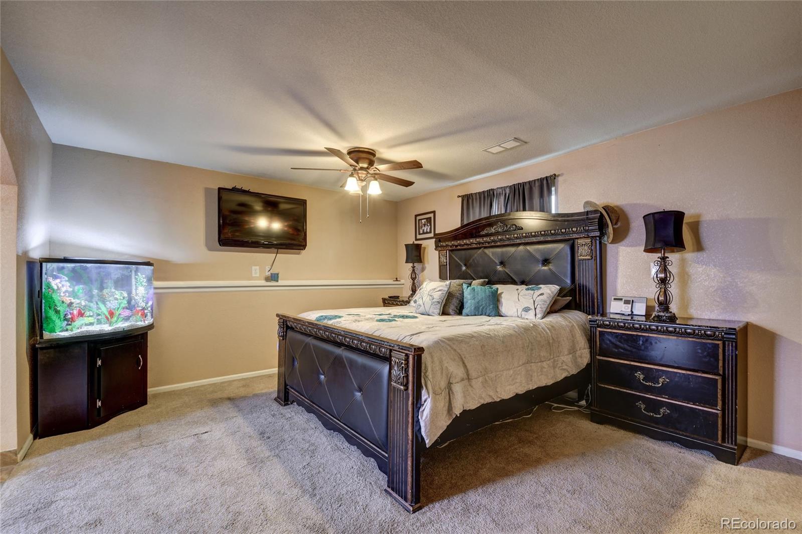 820 South Denver Avenue Fort Lupton, CO 80621 - Photo 6 of 40 a bedroom with a bed and a flat screen tv