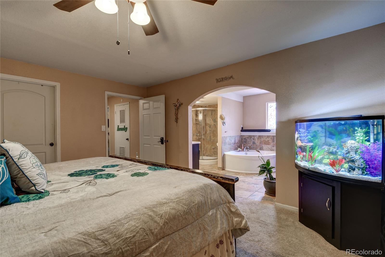 820 South Denver Avenue Fort Lupton, CO 80621 - Photo 7 of 40 a bedroom with a bed and a flat screen tv