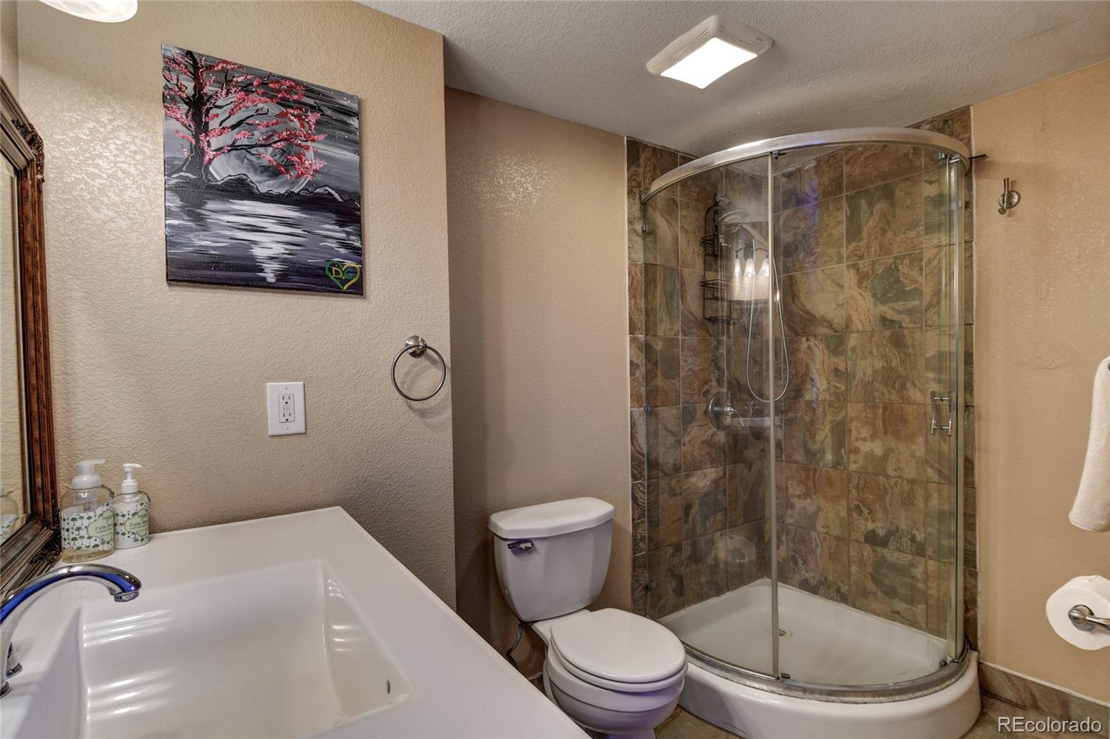 820 South Denver Avenue Fort Lupton, CO 80621 - Photo 9 of 40 a bathroom with a toilet a sink and shower