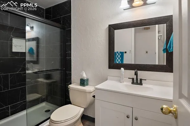 a bathroom with a toilet a sink and mirror