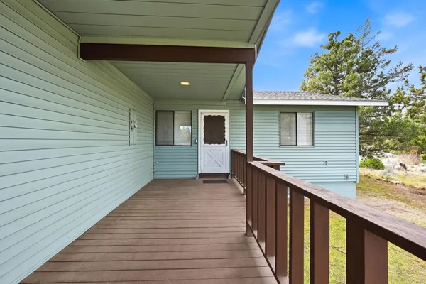 a view of a balcony with wooden floor and fence