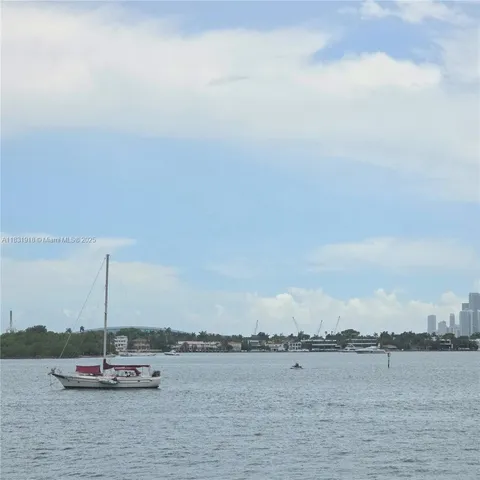 a view of an ocean with boats and trees