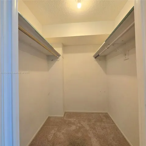 a living room with large window and chandelier