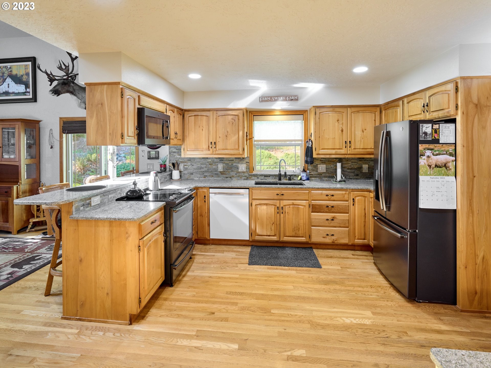 15360 May Road Dallas, OR 97338 - Photo 7 of 48 a kitchen with stainless steel appliances granite countertop a stove top oven a refrigerator a sink and dishwasher with wooden floor