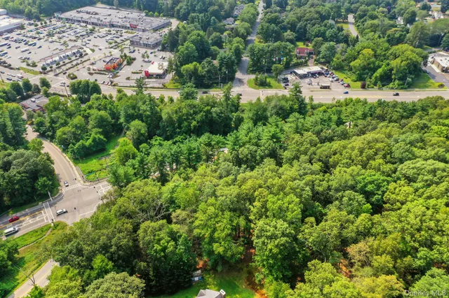 an aerial view of residential house with outdoor space and trees all around